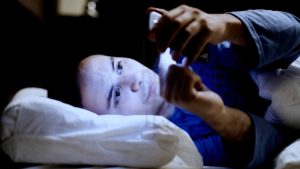 man using mobile on bed